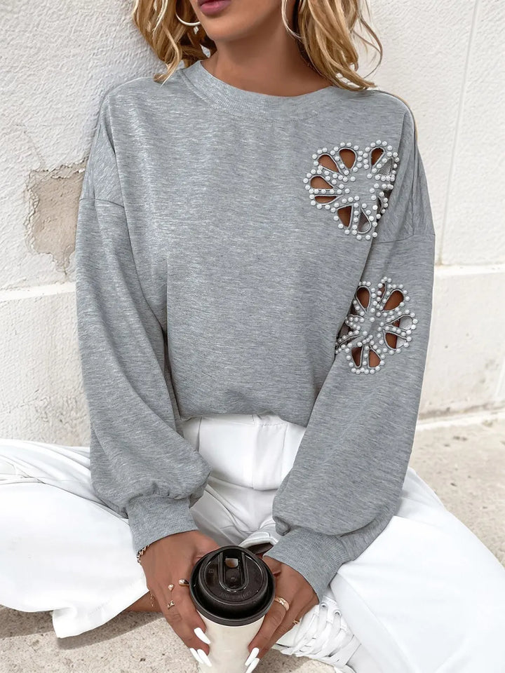 Perfee Cutout Pearl Round Neck Long Sleeve Sweatshirt.